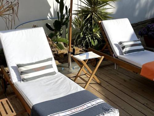 a couple of beds sitting on a porch at VILLA 'Le Refuge' Piscine chauffée 300 m plage in La Tranche-sur-Mer