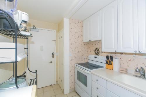 a kitchen with white cabinets and a stove top oven at Ilikai Marina 985 in Honolulu