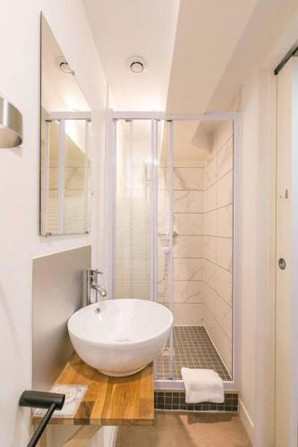 une salle de bain blanche avec un lavabo et une douche dans l'établissement Le Manhattan Monkey :au coeur du centre historique, à Dijon