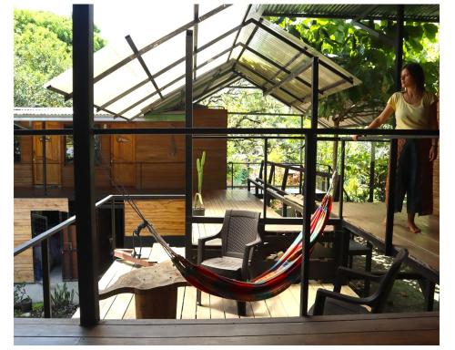 a woman standing on a porch with a hammock at Terrazas del Golfo in La Palma