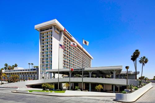 a hotel building with palm trees in front of it at Los Angeles Airport Marriott in Los Angeles