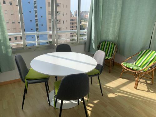 einen Tisch und Stühle in einem Zimmer mit Fenster in der Unterkunft SERVICE APART LAZARO- Apartamentos Aguamarina 58 in Calpe