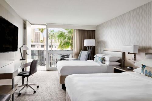 a hotel room with two beds and a balcony at Los Angeles Airport Marriott in Los Angeles