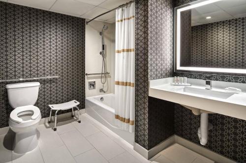 a bathroom with a toilet and a sink and a tub at Los Angeles Airport Marriott in Los Angeles