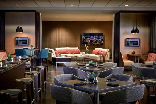 a restaurant with tables and chairs and a couch at Los Angeles Airport Marriott in Los Angeles