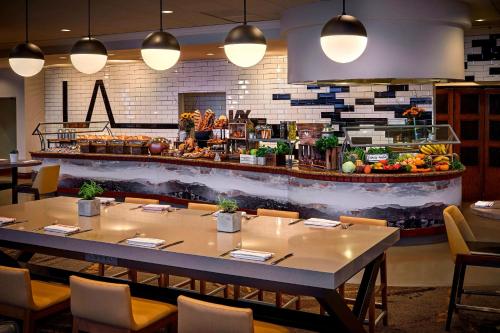 a restaurant with a table and chairs and a counter at Los Angeles Airport Marriott in Los Angeles