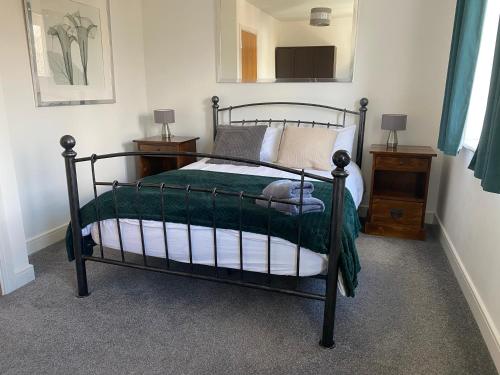 a bedroom with a bed with a green comforter at Watercolour House in Redhill