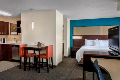 a hotel room with a bed and a table and chairs at Residence Inn Pittsburgh Cranberry Township in Cranberry Township