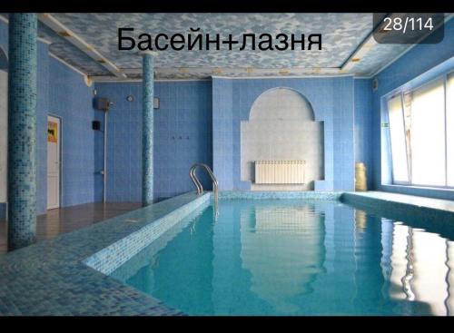 a large swimming pool in a building with blue tiles at Koral Hotel in Verkhniy Koropets