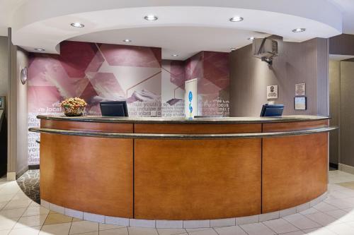 a hotel lobby with a large wooden reception counter at SpringHill Suites by Marriott Denver Airport in Denver