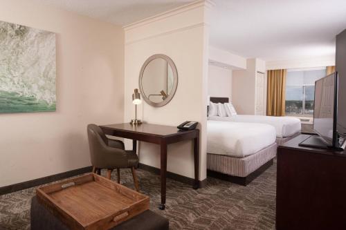 a hotel room with a desk and a bed and a mirror at SpringHill Suites Orlando Airport in Orlando