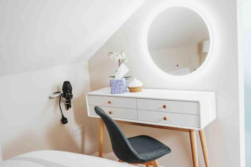 a bedroom with a white dresser and a mirror at The Sea Loft Castlerock. in Castlerock