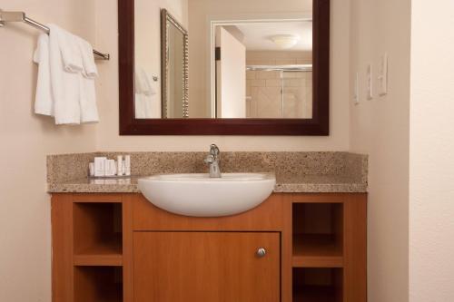 a bathroom with a sink and a mirror at SpringHill Suites Orlando Airport in Orlando