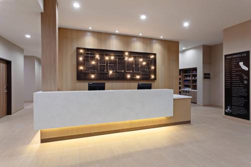 a lobby with a reception desk with lights on the wall at TownePlace Suites by Marriott San Diego Central in San Diego