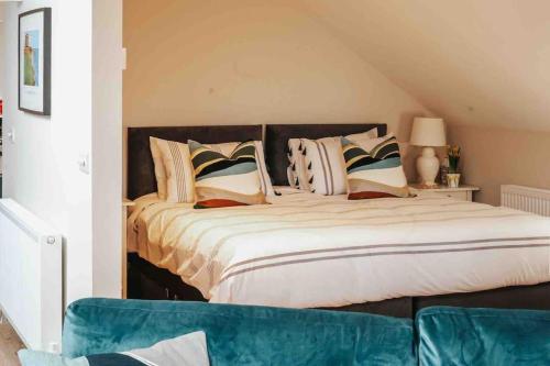 a bedroom with a large bed with pillows at The Sea Loft Castlerock. in Castlerock