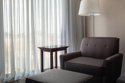 a room with a chair and a table and a lamp at DoubleTree by Hilton Minneapolis Airport, MN in Bloomington