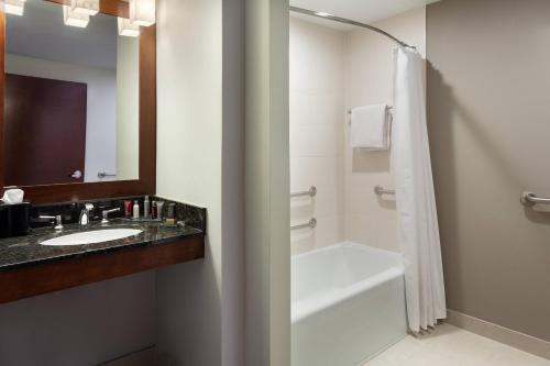 a bathroom with a sink and a tub and a shower at DoubleTree by Hilton Minneapolis Airport, MN in Bloomington