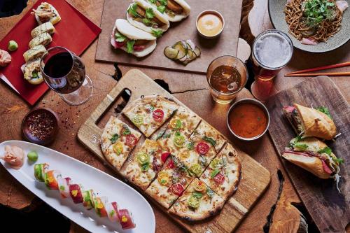 a wooden table with a pizza on a cutting board at Mauna Kea Beach Hotel, Autograph Collection in Hapuna Beach