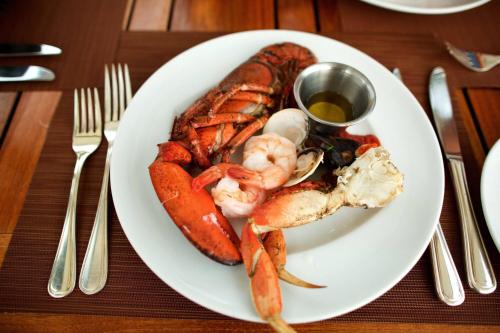 a plate of food with lobster and shrimp on a table at Mauna Kea Beach Hotel, Autograph Collection in Hapuna Beach