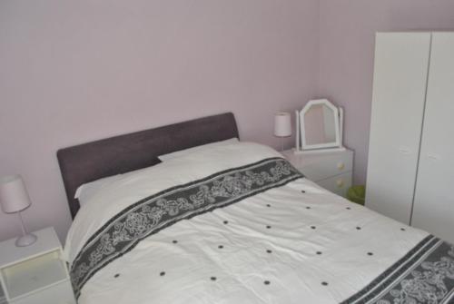 a bedroom with a bed with a gray and white bedspread at Douglas Lodge Holiday Homes in Keadew