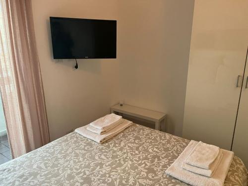 a bedroom with a bed with a tv on the wall at Ortigia D'aMare Apartment in Siracusa