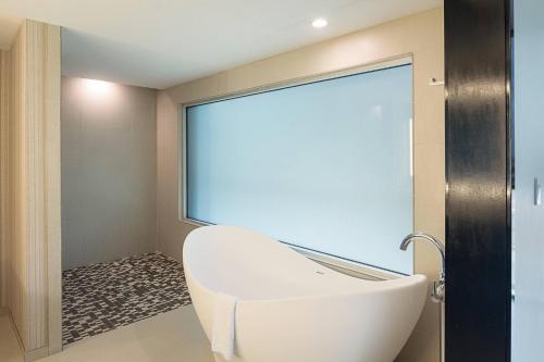 een badkamer met een wit bad en een groot raam bij SpringHill Suites by Marriott Fort Worth Fossil Creek in Fort Worth