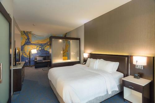 a hotel room with a large bed and a living room at SpringHill Suites by Marriott Fort Worth Fossil Creek in Fort Worth