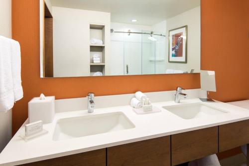 a bathroom with two sinks and a large mirror at Courtyard by Marriott Los Angeles L.A. LIVE in Los Angeles