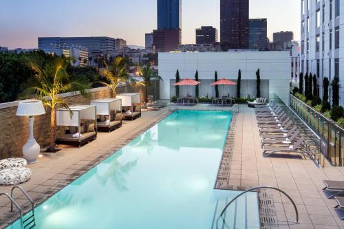 a pool on the rooftop of a hotel with chairs and a city at Courtyard by Marriott Los Angeles L.A. LIVE in Los Angeles