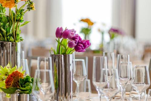 a table with wine glasses and vases with flowers at Courtyard by Marriott Los Angeles L.A. LIVE in Los Angeles