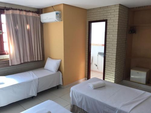um quarto de hotel com duas camas e uma janela em Rede Andrade Goiania Centro em Goiânia