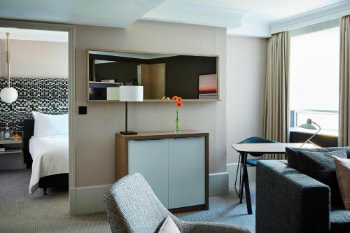 a hotel room with a bed and a couch and a table at London Marriott Maida Vale in London