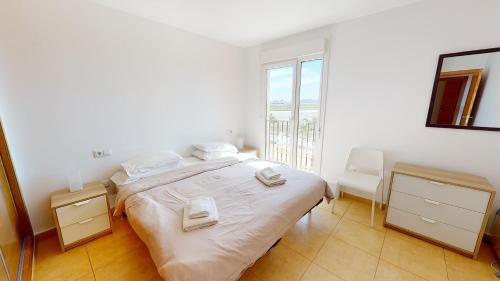 トレ・パチェコにあるApartment Mar Menorの白いベッドルーム(大型ベッド1台、窓付)