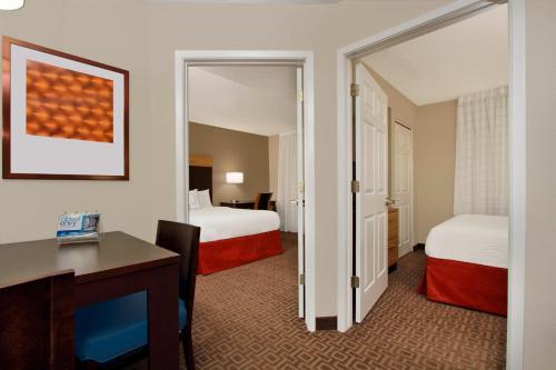 TownePlace Suites Fort Worth Southwest TCU Area في فورت وورث: غرفة فندقية بسريرين ومكتب