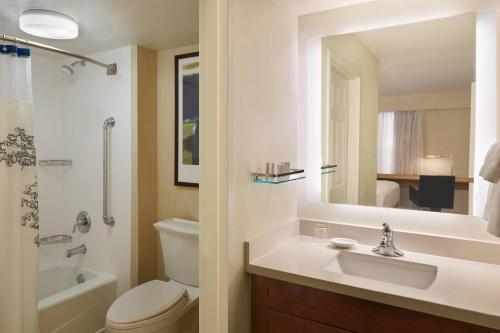 a bathroom with a sink and a toilet and a mirror at Residence Inn by Marriott Toronto Airport in Toronto
