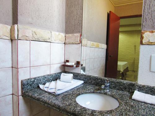 a bathroom with a sink and a mirror at Rede Andrade Goiania Centro in Goiânia