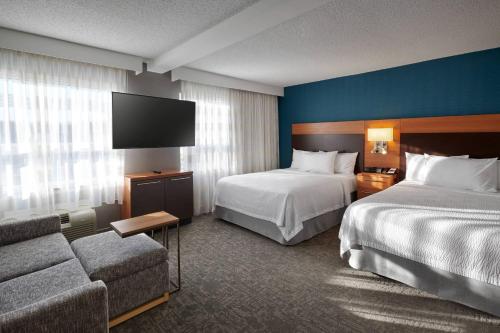 a hotel room with two beds and a flat screen tv at TownePlace Suites by Marriott Mississauga-Airport Corporate Centre in Mississauga
