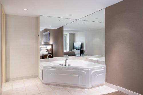 a bathroom with a bath tub with a large mirror at Delta Hotels by Marriott St. John's Conference Centre in St. John's