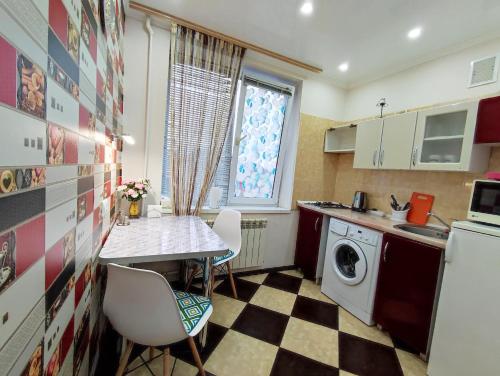 een kleine keuken met een tafel en een wastafel bij Apartment on Suvorova in Bender