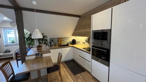 a kitchen with white cabinets and a table with chairs at Villa Gallistl in Český Krumlov