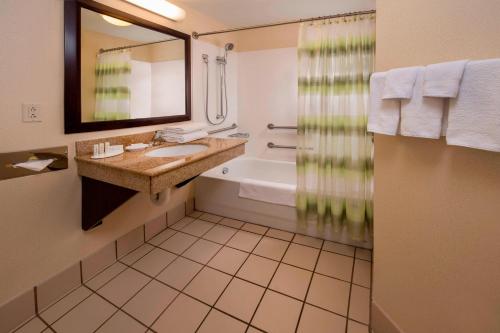 uma casa de banho com um lavatório, uma banheira e um espelho. em Springhill Suites by Marriott State College em State College
