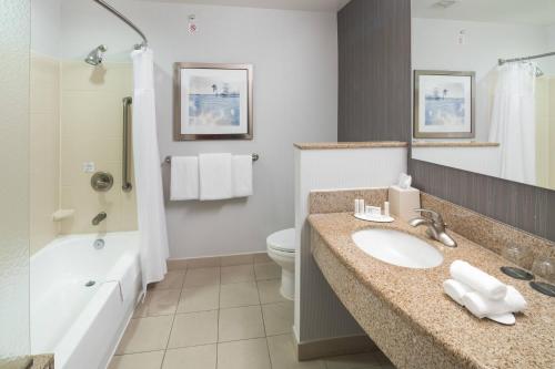 a bathroom with a sink and a toilet and a tub at Courtyard by Marriott West Orange in West Orange