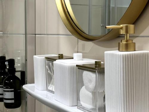uma prateleira com três toalhas brancas e um espelho em DLC exklusives Studio im Zentrum em Bad Pyrmont