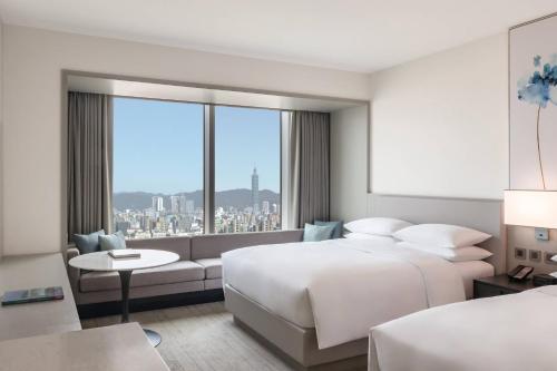 台北市にあるCourtyard by Marriott Taipei Downtownのベッド2台と大きな窓が備わるホテルルームです。