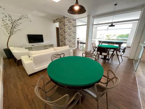 a living room with a green table and chairs at Apartamento familiar em Riviera de São Lourenço Módulo 8 in Bertioga
