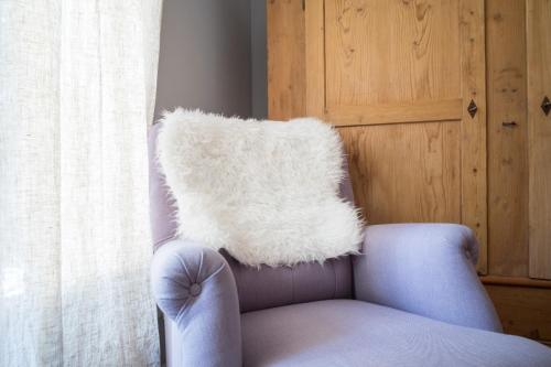 ein weißes Kissen auf einem Stuhl neben einem Fenster in der Unterkunft Landhotel Eifellust in Schalkenmehren