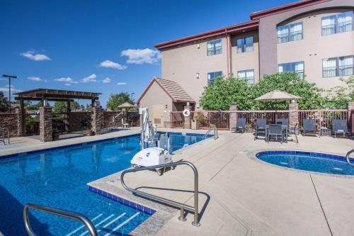 a pool at a hotel with chairs and a building at Residence Inn Prescott in Prescott