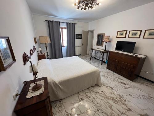 a bedroom with a bed and a flat screen tv at Le Camere dei Magi in Saturnia