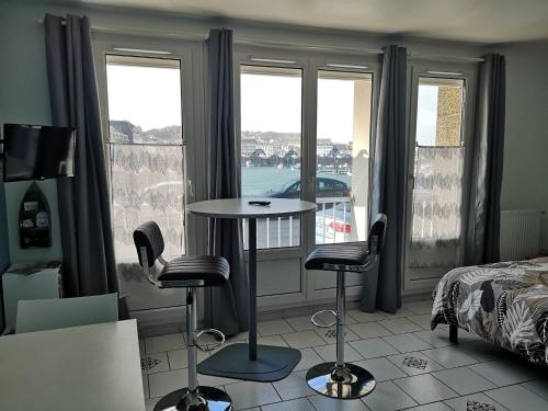 Zimmer mit einem Tisch, 2 Stühlen und einem Fenster in der Unterkunft Abri Côtier-3 étoiles-vue imprenable sur port de plaisance in Fécamp