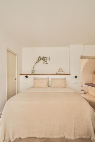 een witte slaapkamer met een groot bed met 2 kussens bij Casa Uva - Boutique Guest House in Vejer de la Frontera